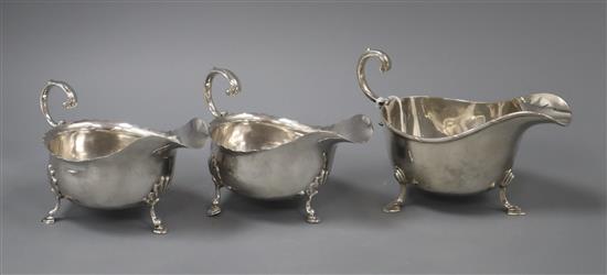 A pair of Edwardian silver sauceboats, Nathan & Hayes, Chester, 1905 and one other silver sauceboat.